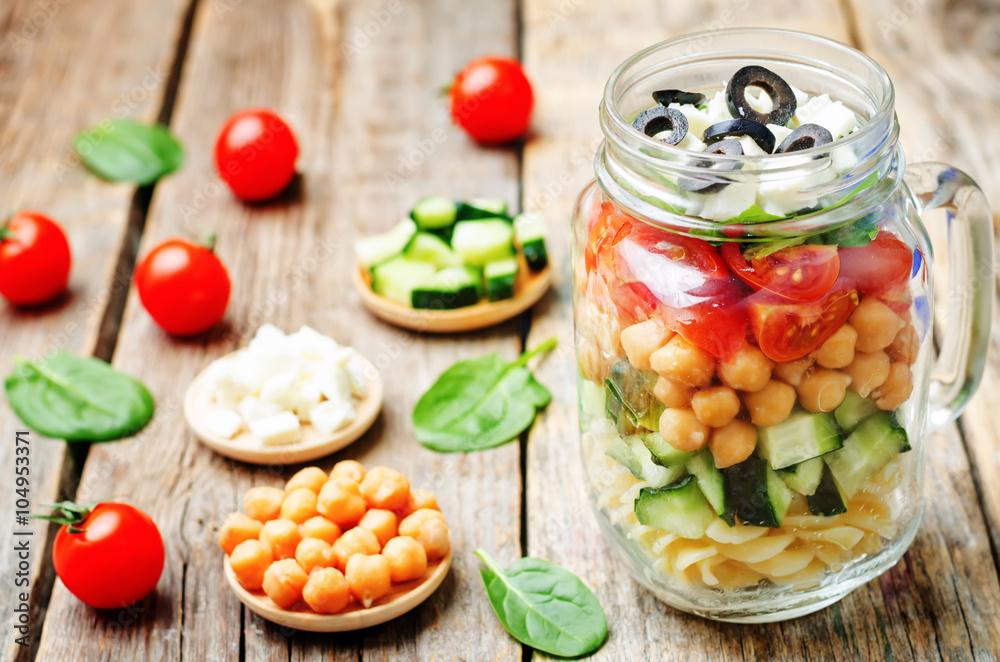 Pasta chickpeas cucumber tomatoes spinach goat cheese salad in a Pasta chickpeas cucumber tomatoes spinach goat cheese salad in a
