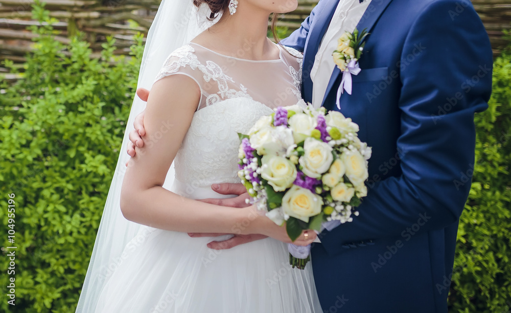 Elegant bride and groom posing together outdoors on a wedding day Elegant bride and groom posing together outdoors on a wedding day