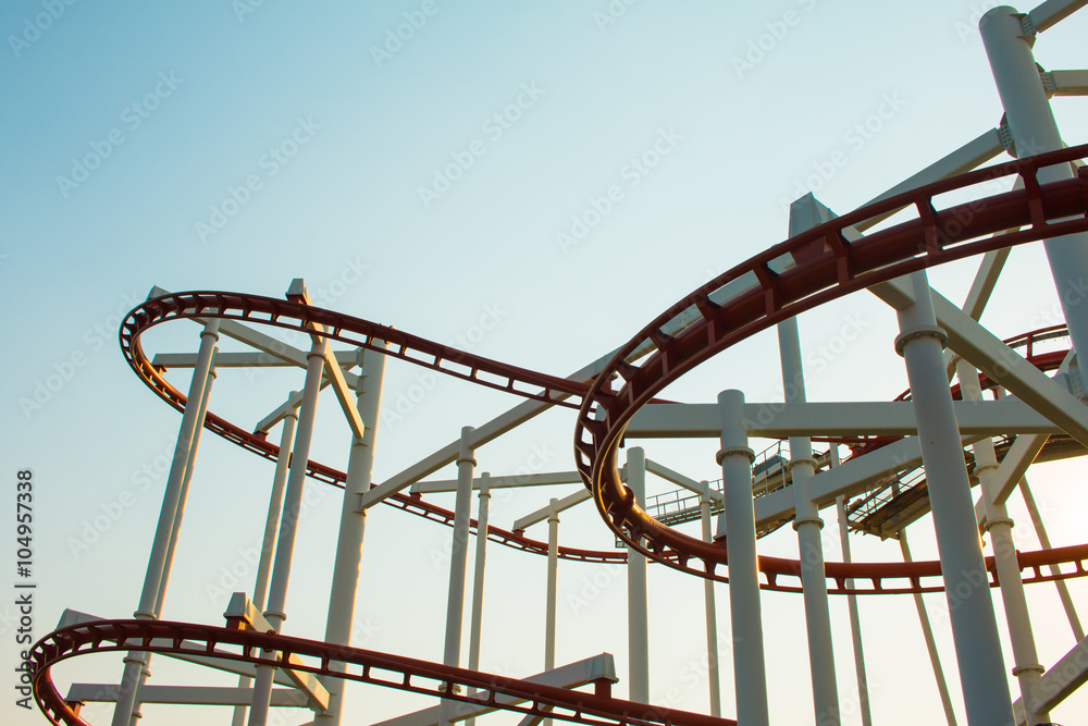 Theme Park Rollercoaster against blue sky .