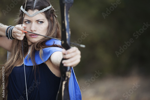 фотографія female archer with bow and arrow.