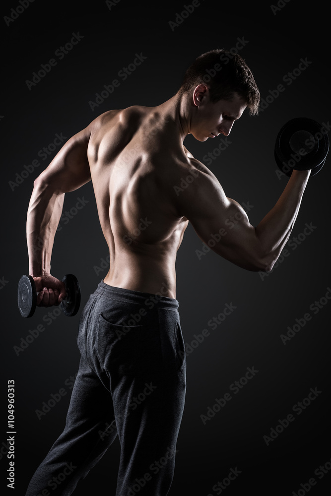 Fitness man doing exercises with dumbbells at biceps, rear view