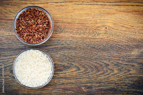 White and Red Rice in Glass Cup on Wooden Background