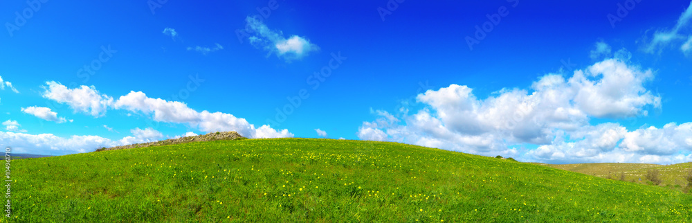 Collina verde e cielo azzurro con nuvole