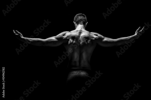 Rear view of muscular man with his arms stretched out