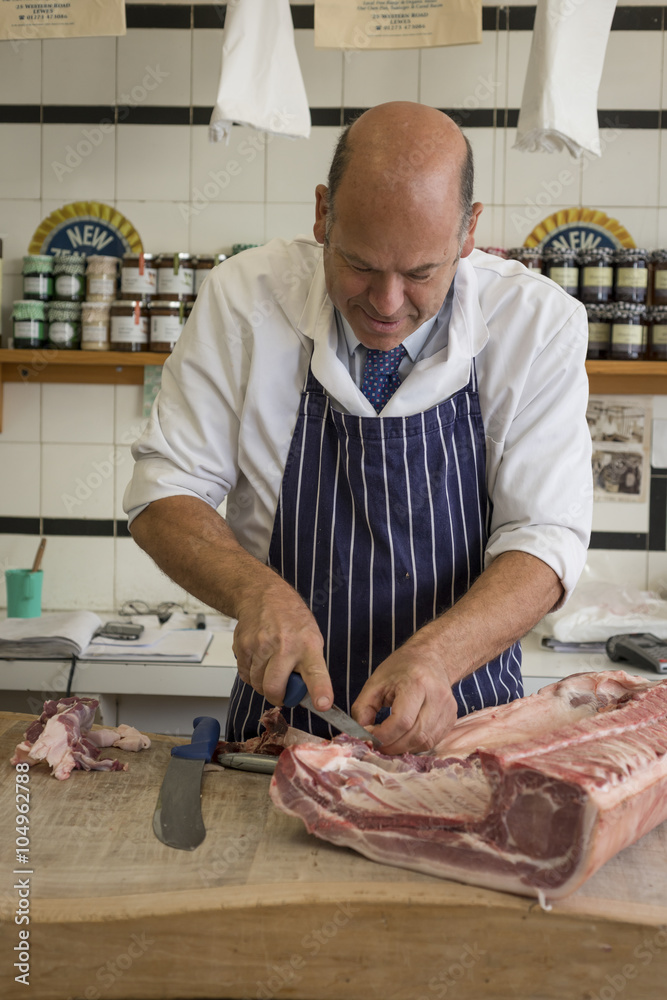 Butchering a rack of raw pork with a sharp knife Butchering a rack of raw pork with a sharp knife