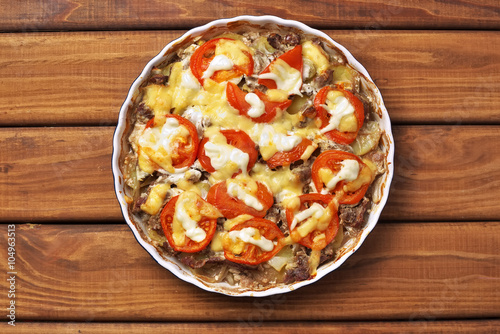 Cooked potato with meat, tomato, cheese and mayonnaise in round