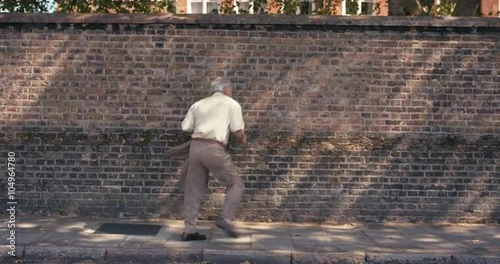 Contemporary funky elderly man street dancer dancing freestyle in the city