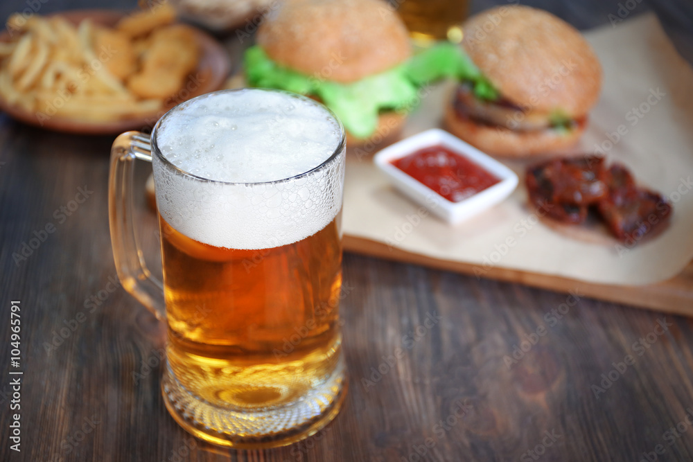 Glass mug of light beer with snacks on dark wooden table, close up Glass mug of light beer with snacks on dark wooden table, close up