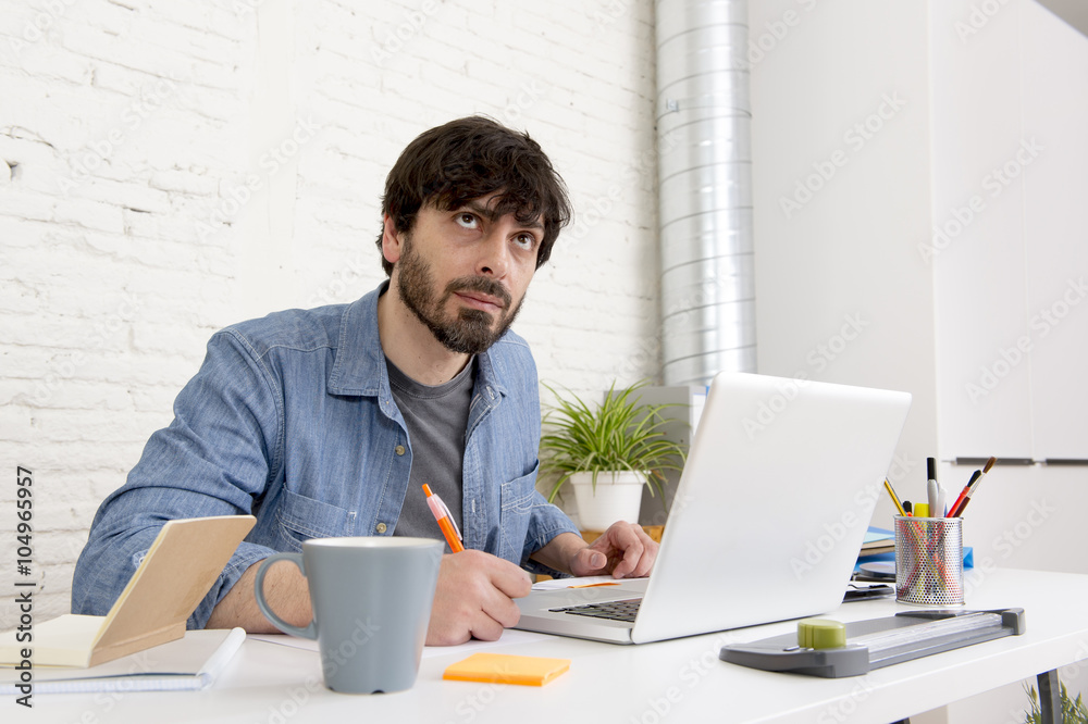 young hispanic hipster businessman working at computer home office young hispanic hipster businessman working at computer home office