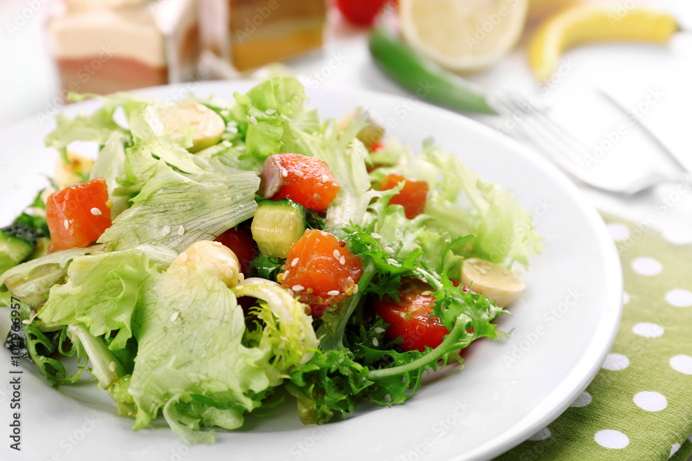 Tasty salmon salad on light wooden background