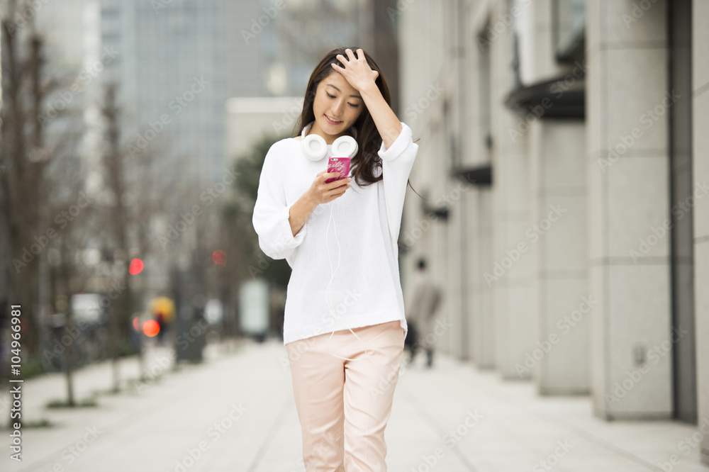 Woman is walking while looking at the smartphone