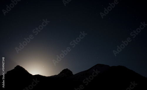 moon set behind the mountain silhouettes