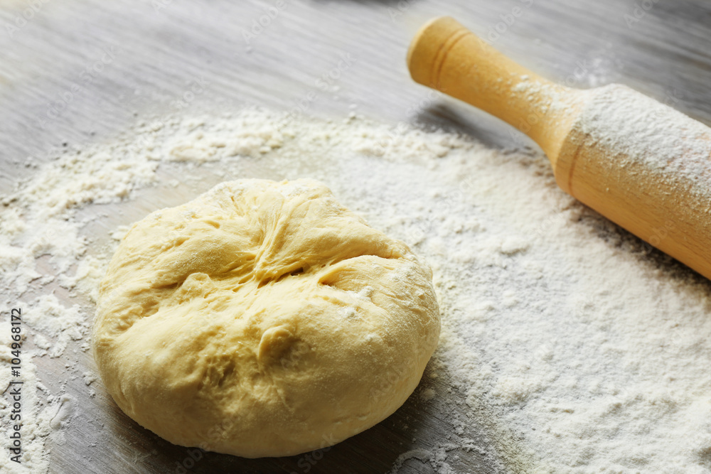 Fresh prepared dough on a wooden board, close up Fresh prepared dough on a wooden board, close up
