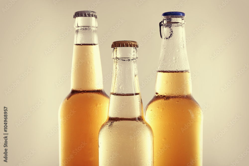 Glass bottles of lager beer on light grey background Glass bottles of lager beer on light grey background