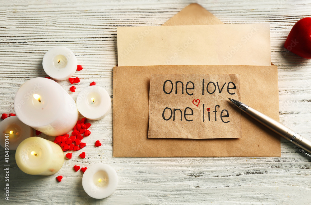 Φωτογραφία Gift card for Valentine's Day with inscription, pen and candles on white wooden