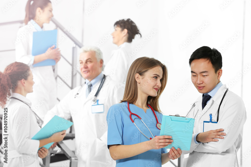 Speaking doctors and their colleagues on background indoors Speaking doctors and their colleagues on background indoors