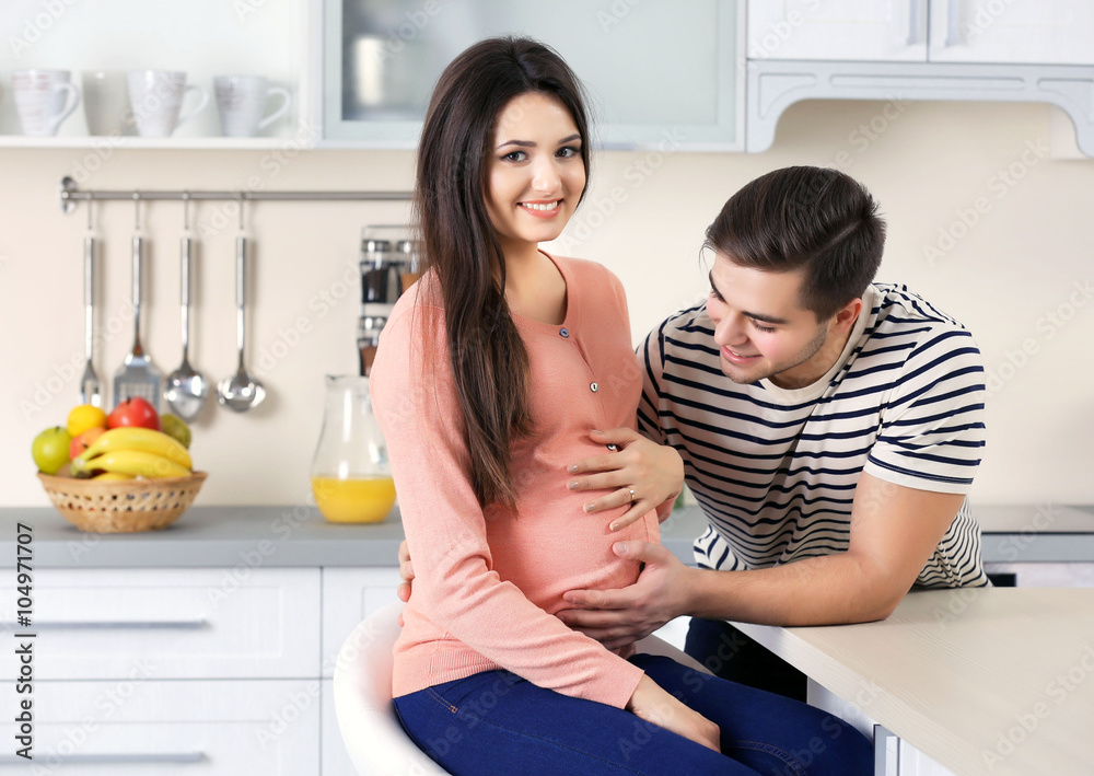 Pregnant woman with husband in the kitchen Pregnant woman with husband in the kitchen