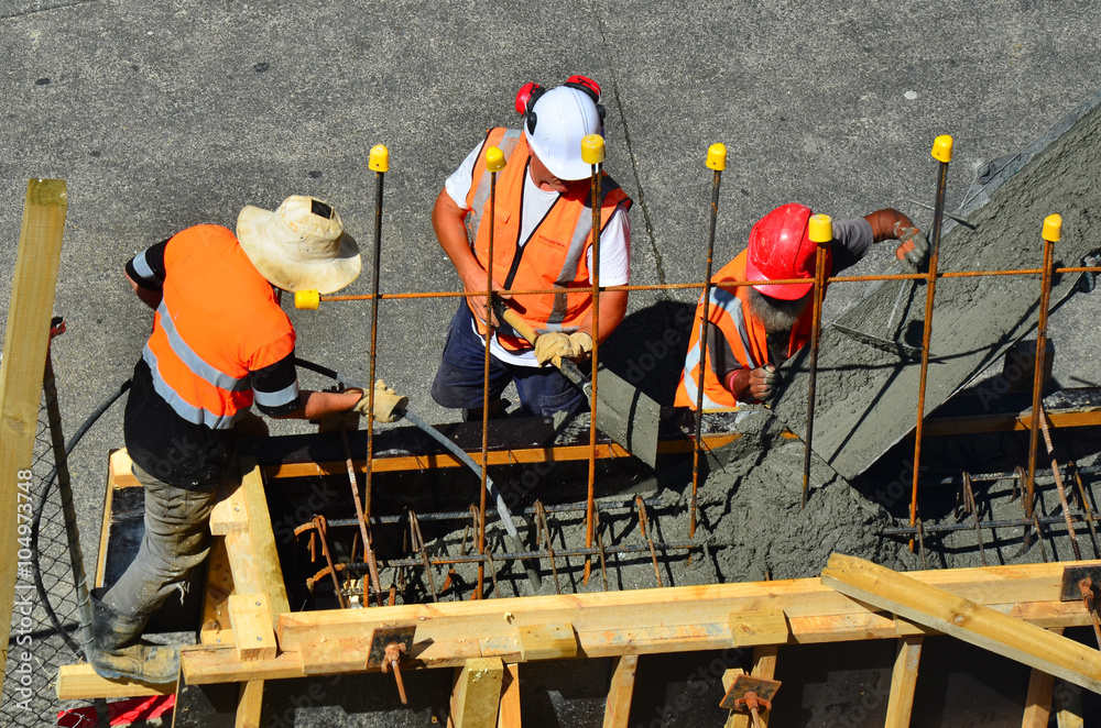 Fototapeta premium Builders pour cement to a concrete wall