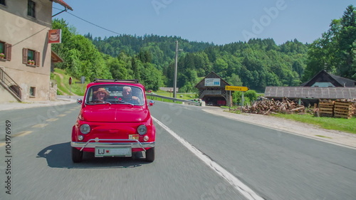 Red vintage zastava driving through a small town photo
