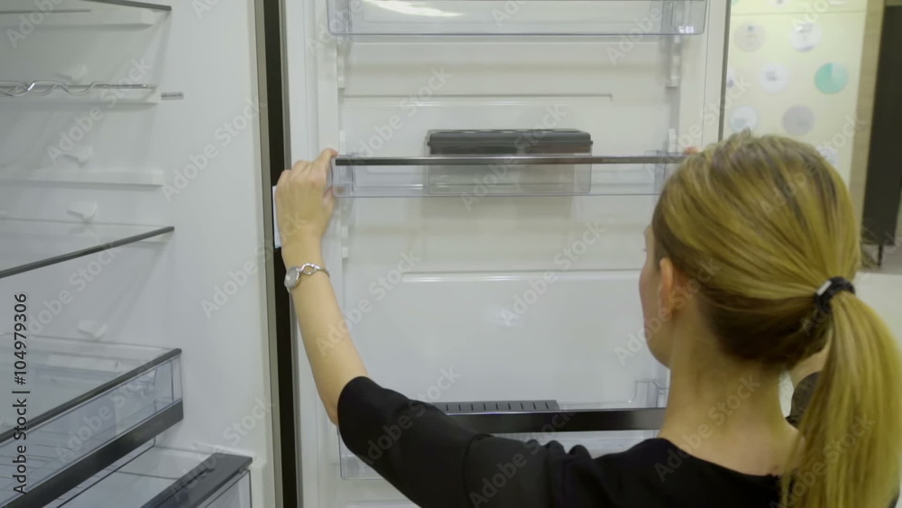 This video shows a lady who is lifting a side shelf up in a fridge and then putting it back on its place. Wide-angle shot.
This video shows a lady who is lifting a side shelf up in a fridge and then putting it back on its place. Wide-angle shot.