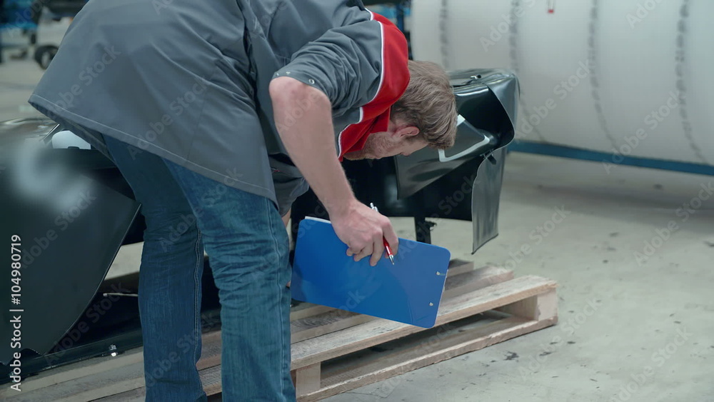 A technician in the factory is checking something A technician in the factory is checking something
