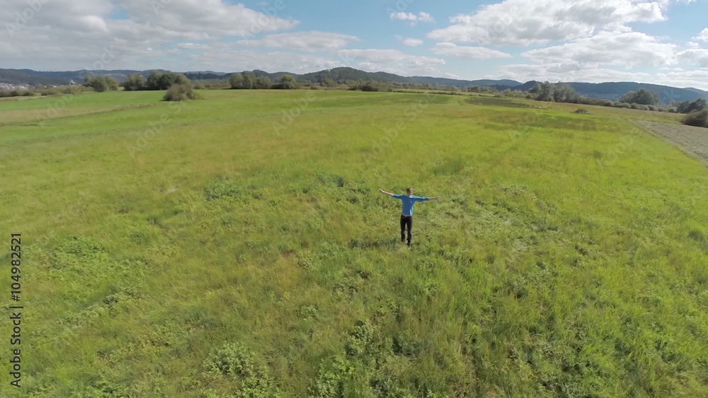 Man with raise their hands on a green grass field Man with raise their hands on a green grass field