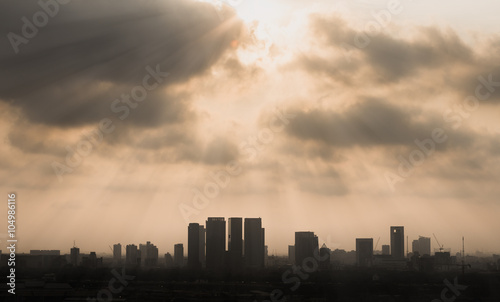 Silhouetted city under sun ray