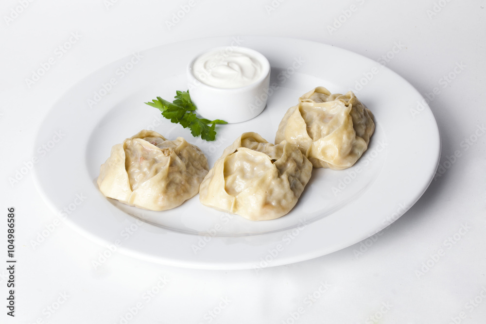 manti dumplings ravioli great big huge with sour cream and parsley on a plate menu for the cafe restaurant isolated white background manti dumplings ravioli great big huge with sour cream and parsley on a plate menu for the cafe restaurant isolated white background