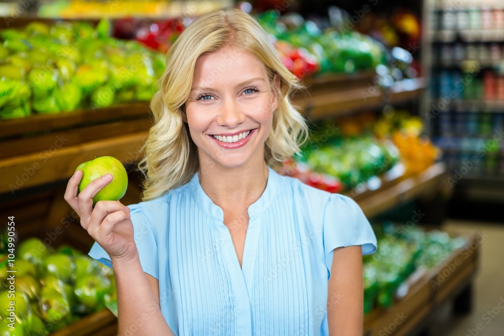 Smiling woman holding green apple Smiling woman holding green apple
