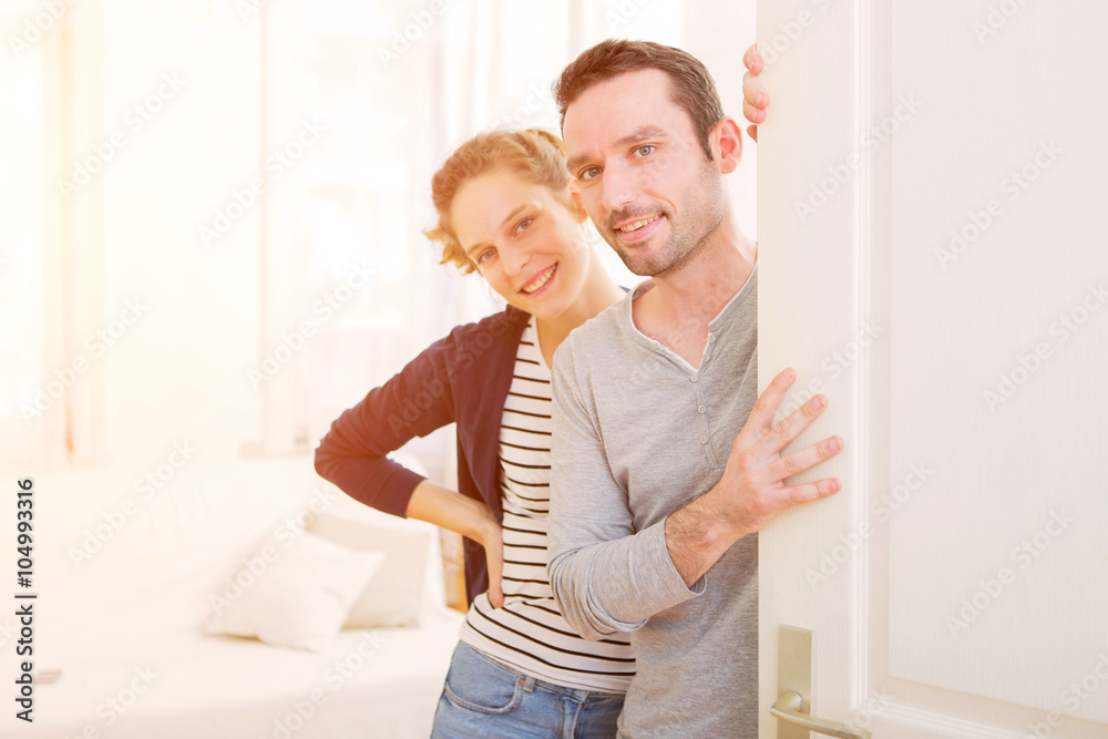 Young attractive couple welcoming you in his house Young attractive couple welcoming you in his house