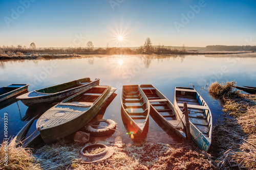 River and old rowing fishing boats at beautiful sunrise sunset