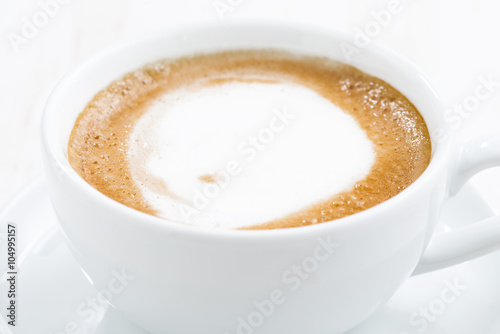 cup of cappuccino on a white wooden table, selective focus 