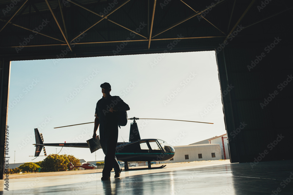 Naklejka premium Helicopter pilot arriving at airplane hangar