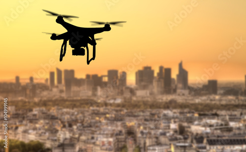 Drone silhouette flying above Paris city panorama