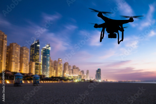 Drone silhouette flying above Dubai city panorama