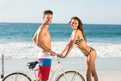 Couple going on a bike ride on the beach 