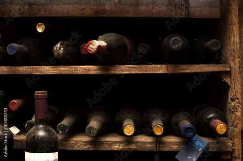 dusty wine bottles inside wine cellar photo