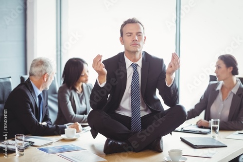 Businessman meditating in conference room