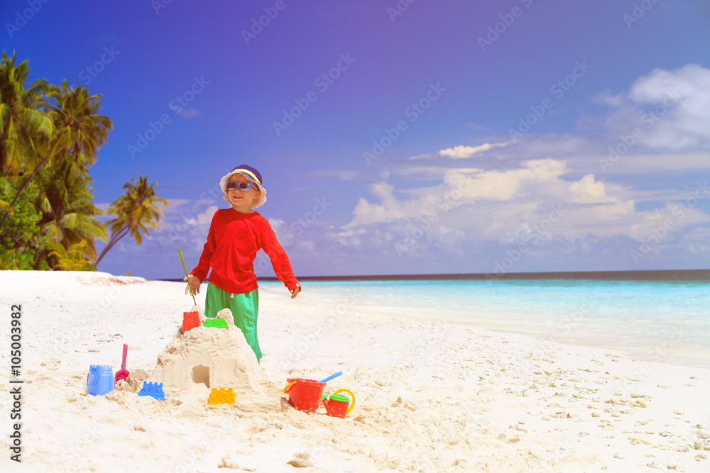 little boy building sandcastle on beach little boy building sandcastle on beach