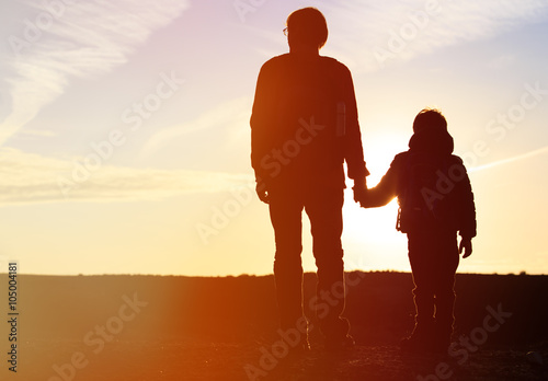 father and son travel at sunset