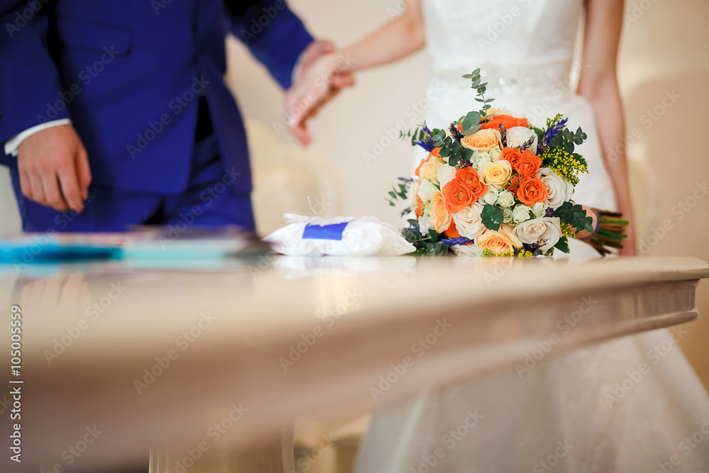 Bridal bouquet on table during the ceremony of marriage registration. Copy space. Bridal bouquet on table during the ceremony of marriage registration. Copy space.