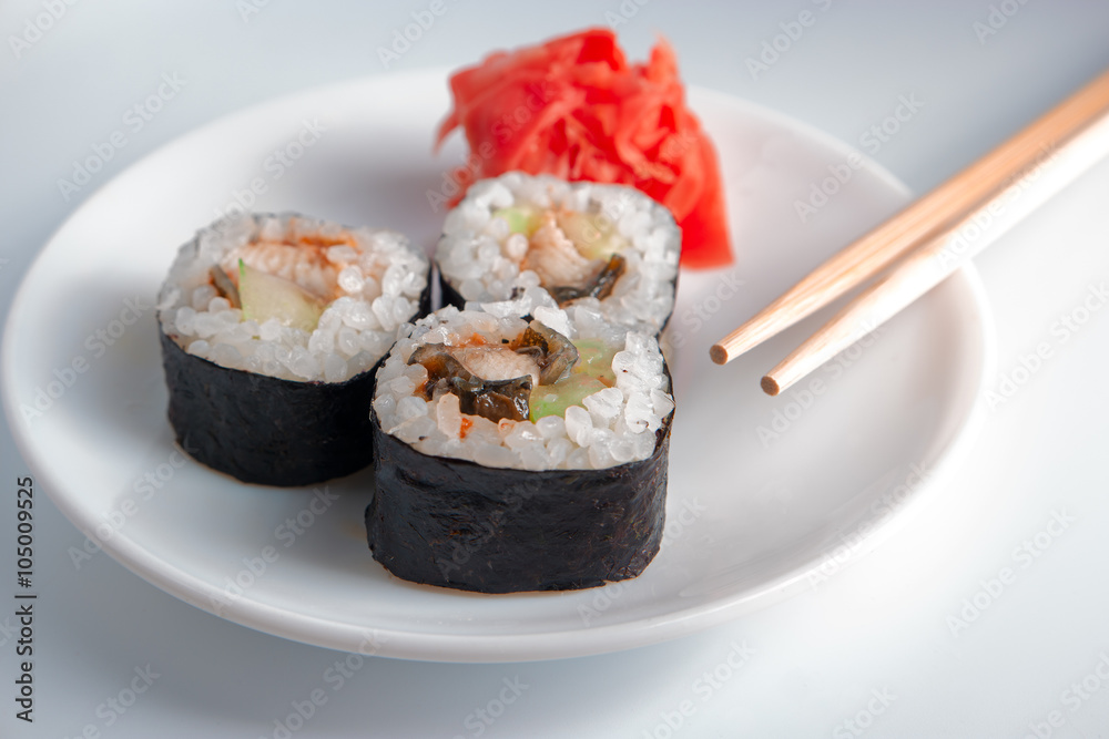 Homemade Seafood Maki sushi in white plate on gray background Homemade Seafood Maki sushi in white plate on gray background