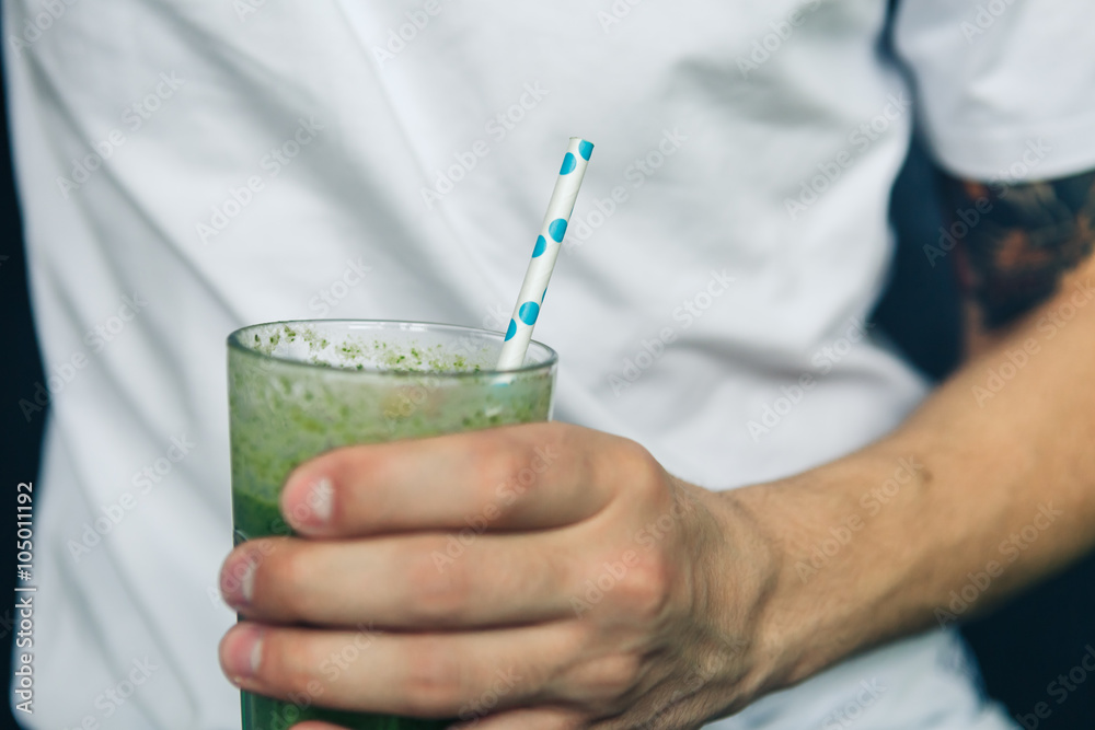 Man holding a glass of green smoothie Man holding a glass of green smoothie