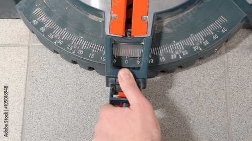 Man sets the cut angle of miter saw