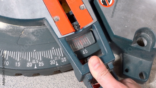 Man sets the cut angle of miter saw