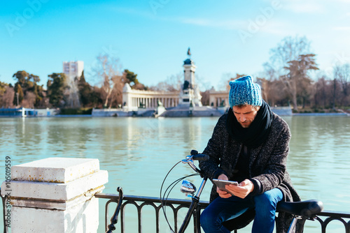 Man reading his ebook in a Park in Madrid
