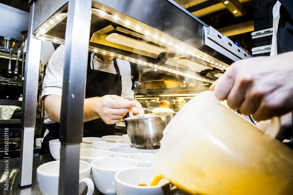 Köche füllen Suppe in Schalen