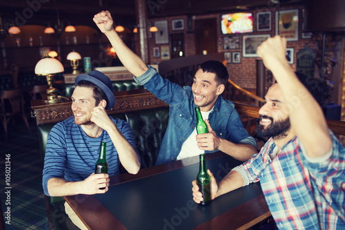 happy male friends drinking beer at bar or pub photo