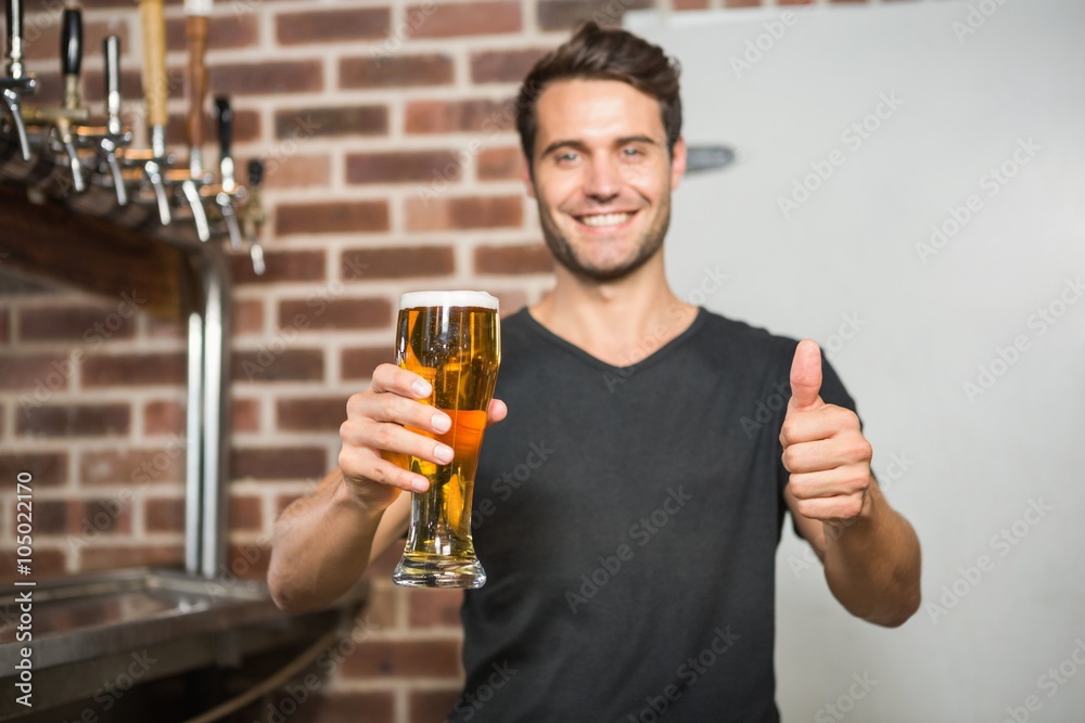 Handsome man holding a pint of beer with thumbs up Handsome man holding a pint of beer with thumbs up