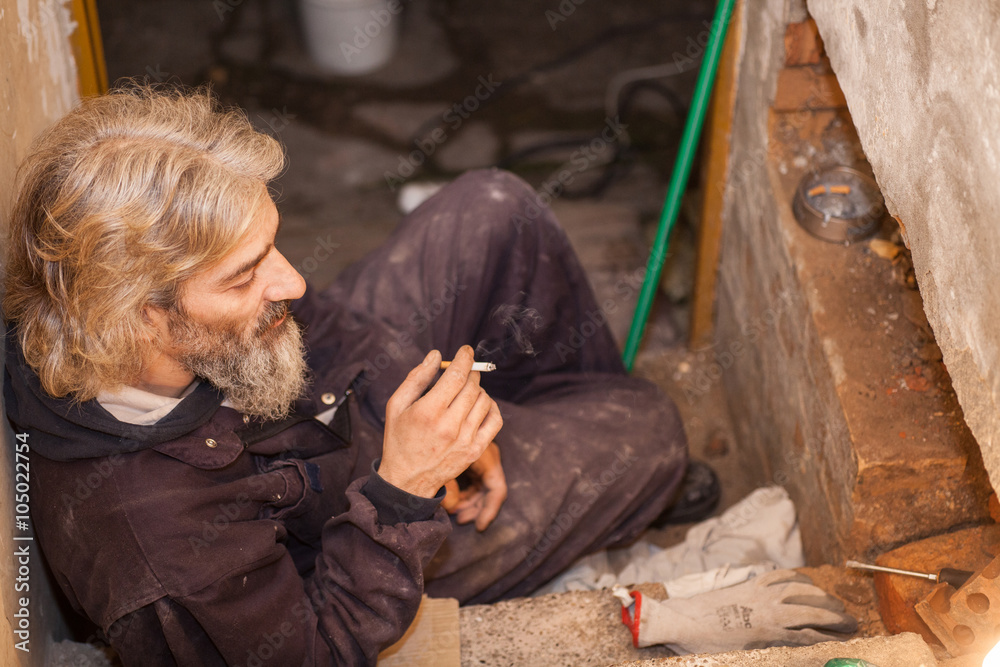 worker resting and smokes cigarette after work